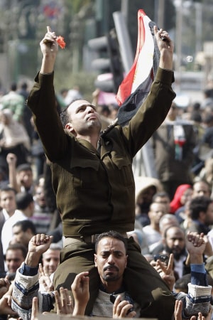 Un homme portant un uniforme de capitaine de l'armée égyptienne est porté par la foule rassemblée lundi place Tahrir.
