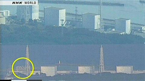 Image de la télévision japonaise NHK montrant deux photos de la centrale nucléaire Fukushima No. 1. Celle du bas montre que le toit et les murs du bâtiment ont été touchés.