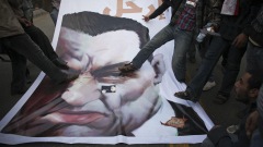 Des manifestants s'en prennent à une affiche d'Hosni Moubarak devant le Parlement au Caire.