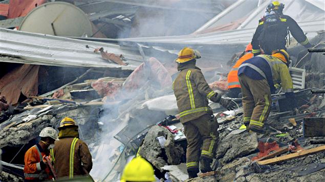 Les pompiers fouillent dans les débris des immeubles détruits.