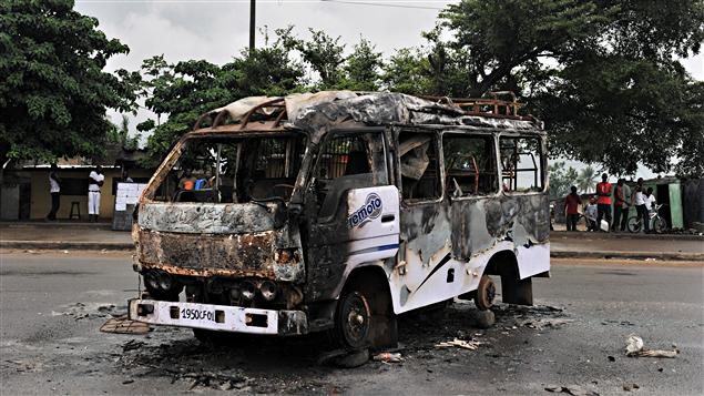 Un autobus incendié dans le district d'Abobo d'Abidjan, un jour après de violents affrontements (23 février 2011)