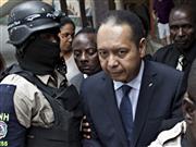 Jean-Claude Duvalier escorté par des policiers, le 18 janvier 2011