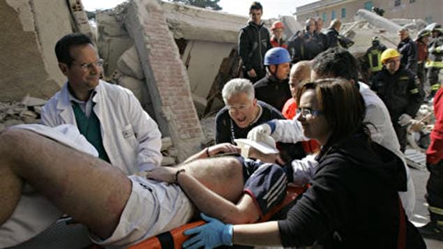 Des secouristes sortent un homme vivant des décombres, dans la ville de L'Aquila, le 6 avril 2009.