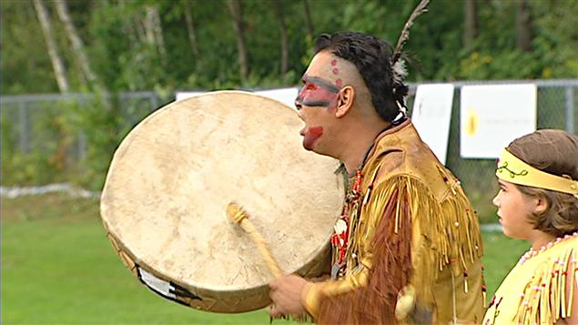 Un Amérindien chante et frappe sur un tambour