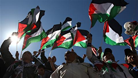 Des manifestants brandissent le drapeau palestinien lors d'une manifestation réclamant l'unité politique des Palestiniens le 15 mars dernier.