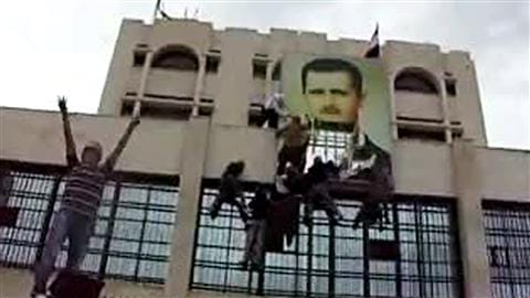 Image tirée d'une vidéo publiée sur YouTube le 13 mai 2011. Des manifestants antirégime déchirent une affiche du président Bachar Al-Assad.