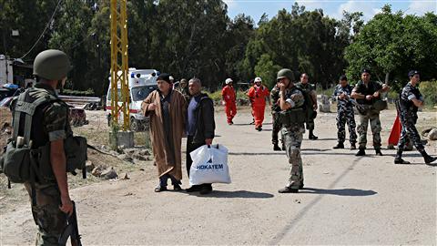 Des soldats libanais encadrent des Syriens à leur arrivée à Wadi Khaled, au Liban