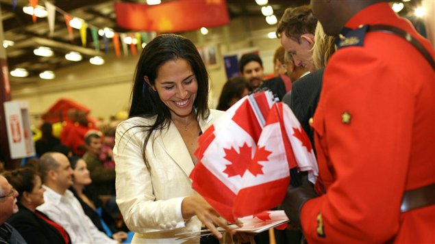 سيدة فرحة بحصولها على الجنسية الكندية في نهاية حفل قسم المواطنة في هاليفاكس في شرق كندا في تشرين الأول (أكتوبر) 2010