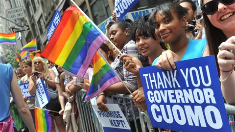 Des New-Yorkais brandissent des affiches remerciant le gouverneur Andrew Cuomo lors du défilé annuel de la Fierté gaie le 26 juin 2011.