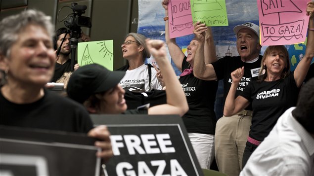 Des militants brandissent des affiches lors d'un point de presse à Athènes, à quelques jours du départ de la flottille vers Gaza.