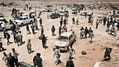 Des rebelles libyens attendent pour faire le plein d'armes près d'un entrepôt de l'armée régulière qu'ils ont saisi mardi, à environ 25 kilomètres au sud de Zenten.