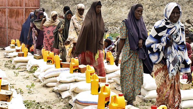 Des femmes reçoivent une ration alimentaire fournie par des organismes d'aide humanitaire dans la région de Mogadiscio en 2011.