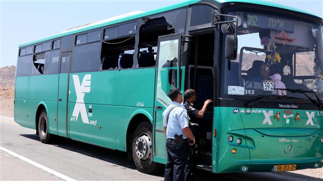 Un policier israélien se tient à côté de l'autobus attaqué par un commando armé, le 18 août 2011.