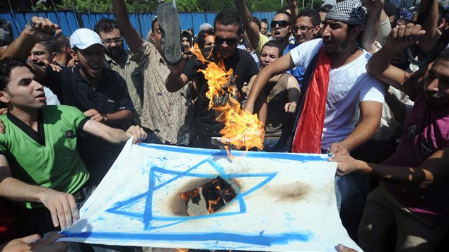 Des Égyptiens brûlent le drapeau israélien devant l'ambassade d'Israël au Caire.