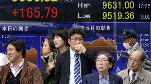 Des Japonais devant un tableau électronique de la Bourse de Tokyo.