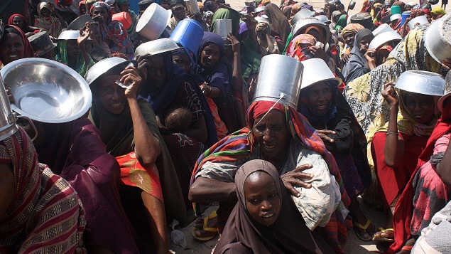 Des familles attendent de l'aide alimentaire dans un camp de réfugiés de Mogadiscio, en Somalie
