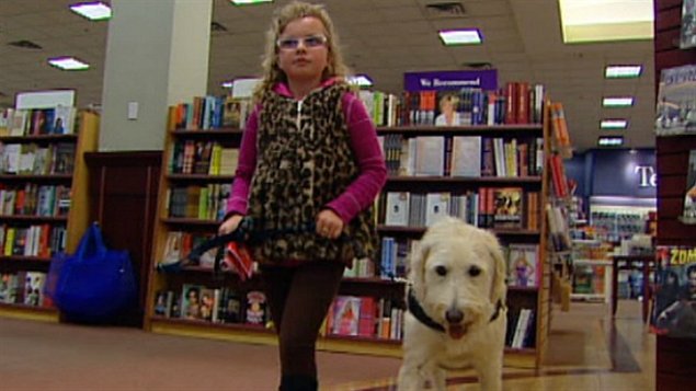 Emily Ainsworth et son chien Levi magasinent dans une librairie d'Edmonton.