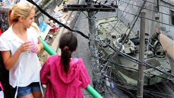 Des habitants de la favela observant les militaires.