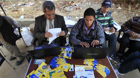 Des membres des Frères musulmans aidaient les électeurs à trouver leur numéro d'inscription à l'extérieur d'un bureau de vote. (28 novembre)