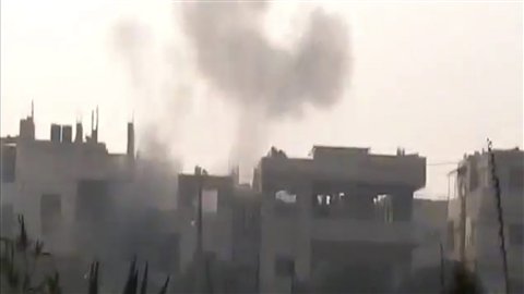 Une image tirée d'une vidéo amateur diffusée par le réseau Shaam News montre un nuage de fumée après un lourd bombardement à Homs, dans le centre de la Syrie.