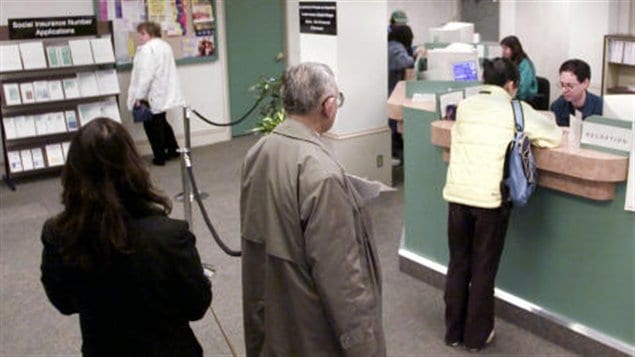Des demandeurs d'emploi font la file dans un bureau d'emploi.