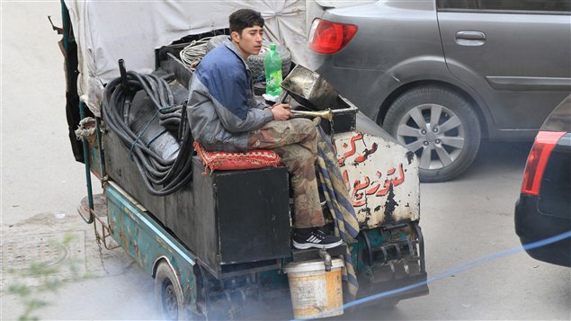 Un jeune syrien vend de l'essence dans un quartier de Damas.