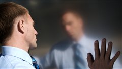 Un homme se regarde dans un miroir
