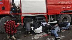 Des journalistes tentent de capter des images derri�re un camion de pompiers au moment o� les forces de s�curit� afghanes tentaient de s�curiser le lieu d'une attaque-suicide � Kaboul, en janvier 2011.