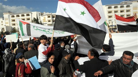 Des manifestants soutenant le régime de Bachar Al-Assad devant l'hôtel où sont réunis les dirigeants de près de 70 pays, à Tunis.