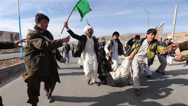 À Herat, en Afghanistan, des manifestants traînent un homme blessé dans les protestations contre l'incinération d'exemplaires du Coran.