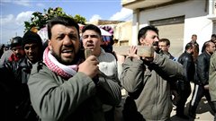 Des Syriens endeuill�s transportent le corps d'un homme qui a �t� tu� par un �clat d'obus dans la r�gion de Homs