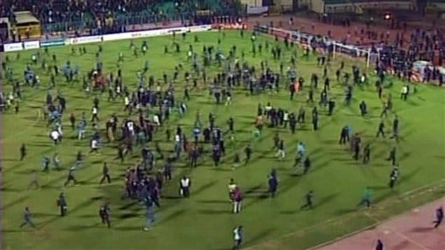 Les amateurs de soccer descendent sur le terrain après la partie, au stade de Port-Saïd, le 2 février 2012.