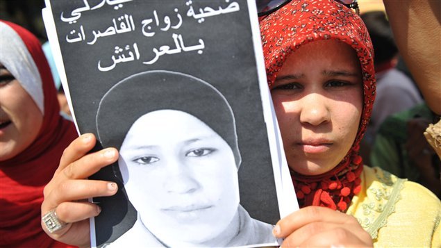 حميدة، شقيقة أمينة الفيلالي، تحمل صورة شقيقتها في اعتصام في مدينة العرائش في شمال المغرب في آذار (مارس) 2012