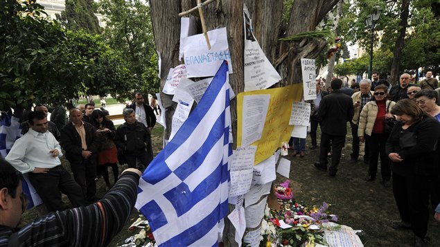 Les gens déposent des offrandes en hommage au retraité de 77 ans qui s'est suicidé devant le Parlement grec