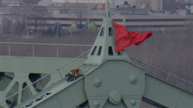 Le carré rouge, symbole de la lutte des étudiants contre la hausse des droits de scolarité, a été hissé vendredi au sommet du pont Jacques-Cartier à Montréal.