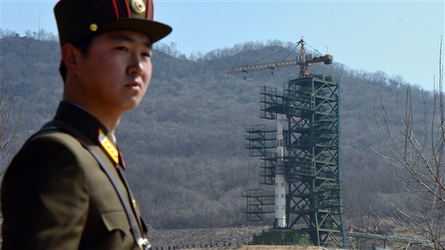 Un soldat nord-coréen monte la garde à proximité de la fusée Unha-3.
