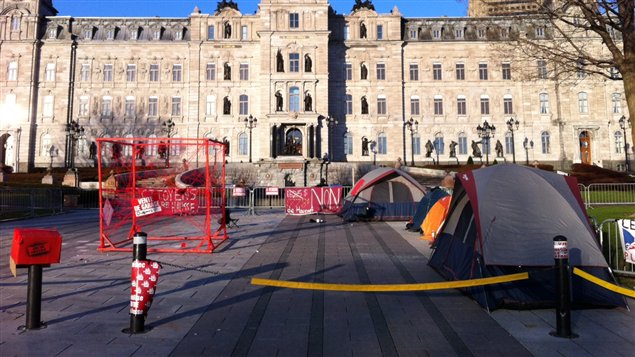 Des structures rouges et des tentes devant l'Assemblée