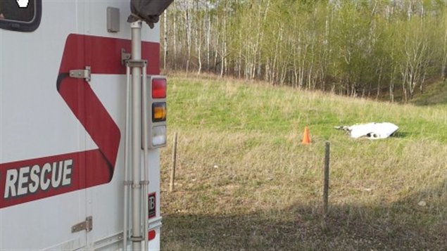 Une ambulance et des débris d'avion dans un champ en Saskatchewan