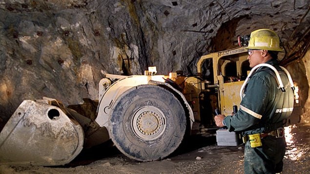 Un ouvrier et de l’équipement lourd dans une mine d’uranium de Cameco
