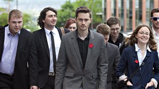 Léo Bureau-Blouin (au centre), arrivant à l'immeuble du boulevard René-Lévesque