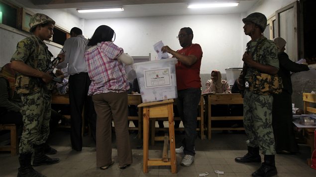 Des soldats à l'intérieur d'un bureau de vote lors du premier tour de l'élection présidentielle le 24 mai 2012.