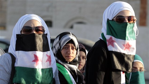 Des femmes syriennes se couvrent la bouche lors d'une manifestation contre le régime de Damas le 13 juin 2012.