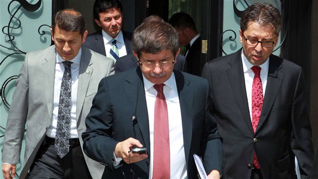 Le ministre turc des Affaires étrangères, Ahmet Davutoglu, et des conseillers avant une entrevue à la télévision publique turque, dimanche 