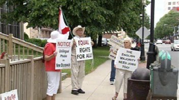 Un groupe de personnes manifeste contre le bilinguisme au Nouveau-Brunswick.