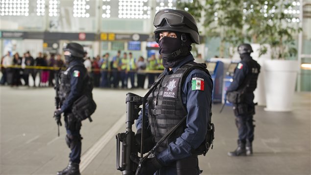 Les policiers fédéraux montent la garde après la fusillade mortelle survenue au terminal 2 de l'aéroport international Benito Juarez de Mexico.