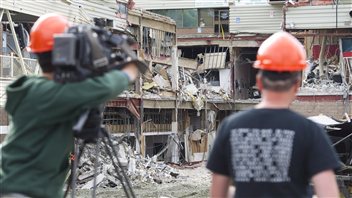 Des ouvriers filment les dommages sur le site de l'effondrement à Elliot Lake.