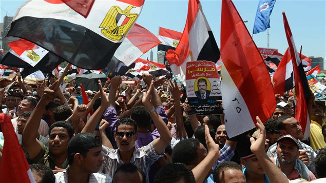 Des manifestants sur la place Tahrir, au Caire, attendant le discours du président Morsi.