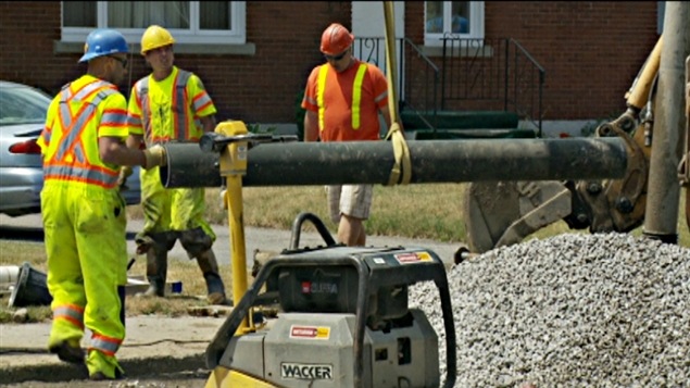 Des employés de la voirie à Ottawa changent une conduite d'eau.