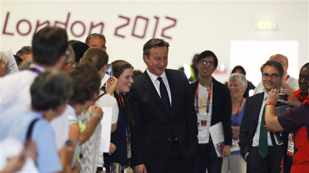 Le premier ministre de la Grande-Bretagne David Cameron pose avec les travailleurs volontaires des JO à un mois du début de l'événement.