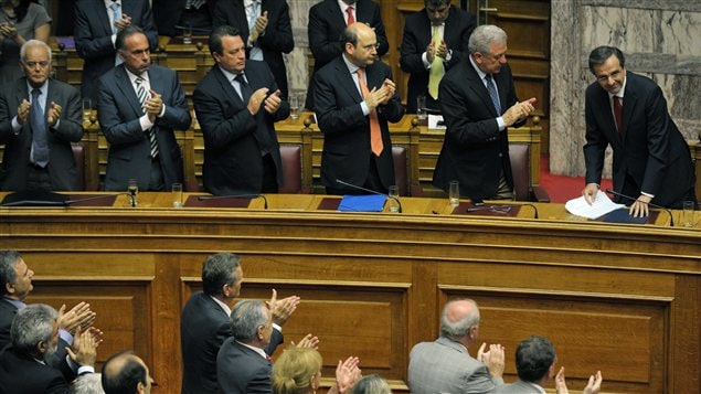 Le premier ministre grec Antonis Samaras est applaudi par ses ministres à l'issue du vote de confiance du Parlement grec le 9 juillet 2012.
